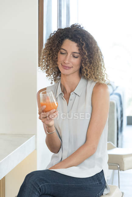 Frau hält Glas mit frischem Karottensaft — Stockfoto