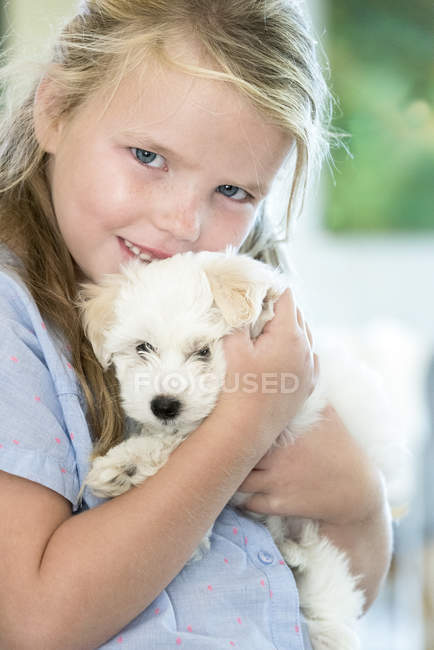 Portrait of cute little girl holding puppy — Stock Photo