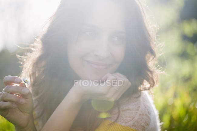 Sorrindo mulher olhando para longe na natureza ensolarada — Fotografia de Stock