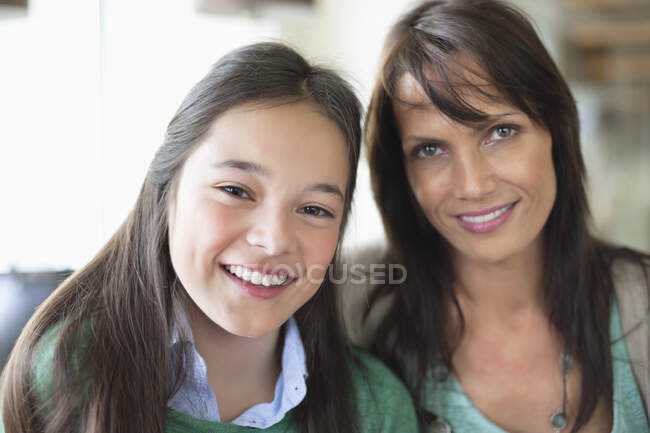 Retrato de una niña sonriendo con su madre - foto de stock