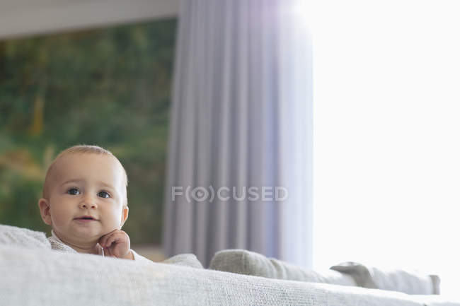 Happy baby girl on couch in living room — Stock Photo