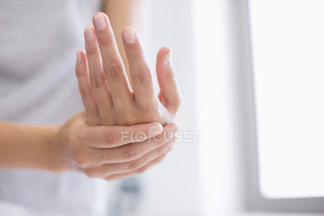 Primo piano di mani femminili che applicano la crema idratante a mani — Foto stock