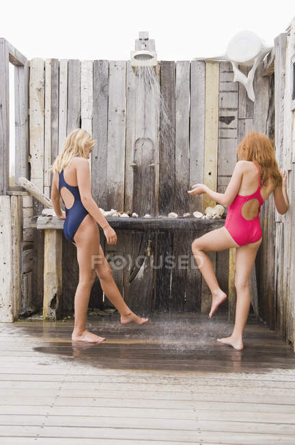 Two girls under a beach shower — Stock Photo