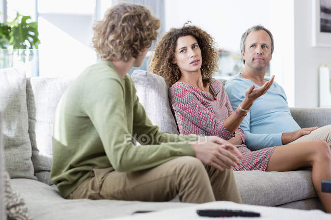 Family talking in living room at home — Stock Photo
