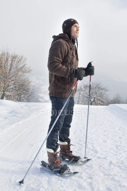 Young man wearing snowshoes in winter mountains — Stock Photo