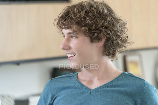 Portrait of happy teenage boy looking away at home — Stock Photo
