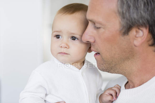 Крупный план отца, держащего милую маленькую дочку дома — стоковое фото