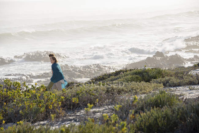 Romantica coppia che cammina sulla costa con tempesta sullo sfondo — Foto stock