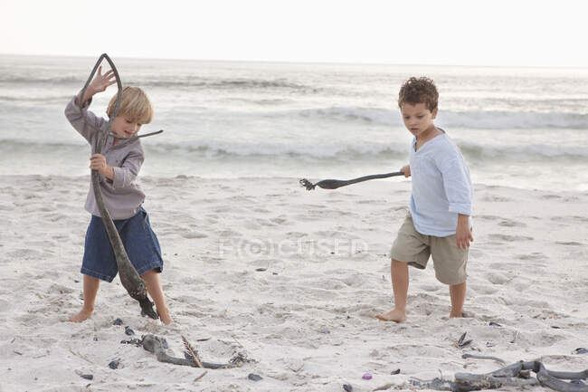 Chicos jugando en la playa - foto de stock