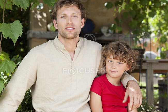 Retrato de padre e hijo con brazo alrededor - foto de stock