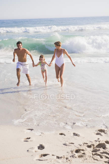 Familia disfrutando de vacaciones en la playa de arena - foto de stock