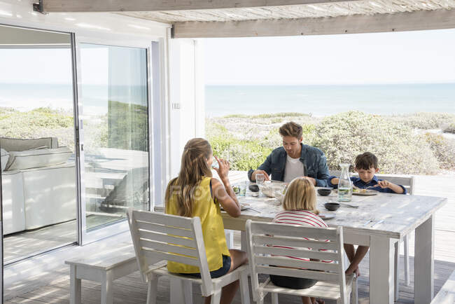 Young family enjoying food at porch — Stock Photo