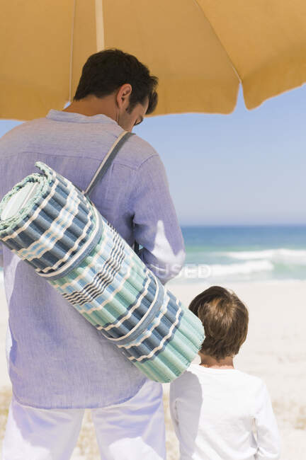 Мужчина с сыном на пляже — стоковое фото