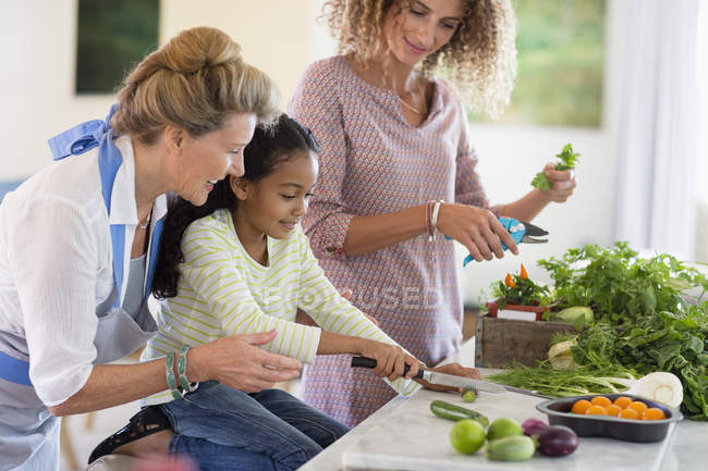 Senior woman with daughter and granddaughter in kitchen — Stock Photo