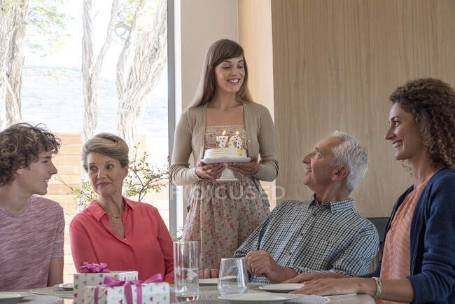 Happy grandparents celebrating birthday with grandchildren at home — Stock Photo