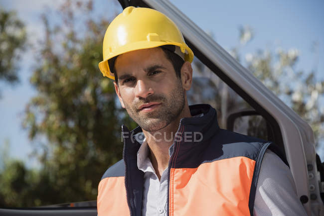 Retrato de engenheiro masculino em capacete em pé na van — Fotografia de Stock