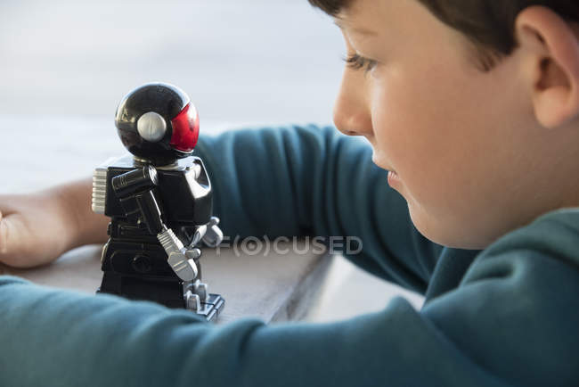 Крупним планом хлопчик грає з іграшковим роботом — стокове фото