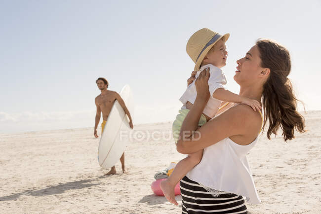 Счастливая молодая семья на пляже — стоковое фото