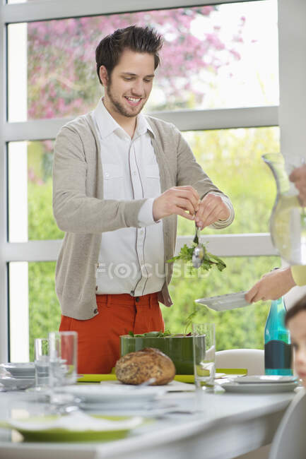 Hombre lanzando ensalada para el almuerzo - foto de stock