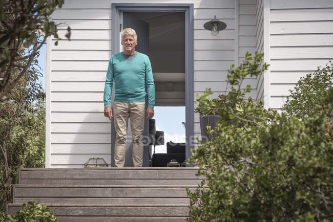 Homme âgé debout à la porte de la maison de campagne — Photo de stock
