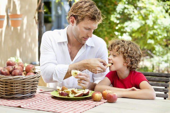 Padre che nutre mele a suo figlio — Foto stock