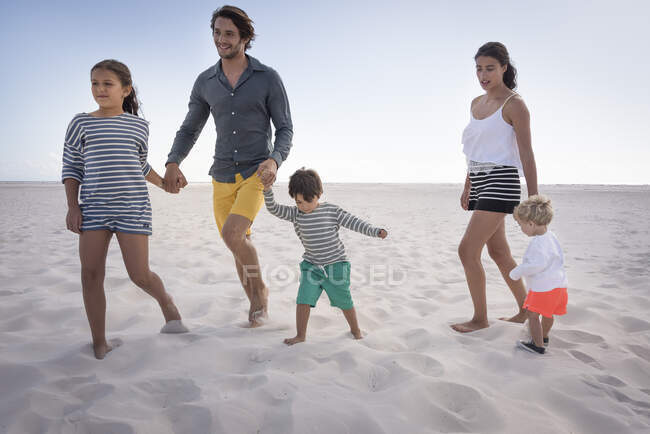 Щаслива молода сім'я насолоджується на пляжі — стокове фото