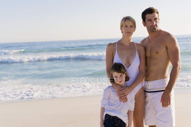 Retrato de família relaxada em pé na praia arenosa — Fotografia de Stock