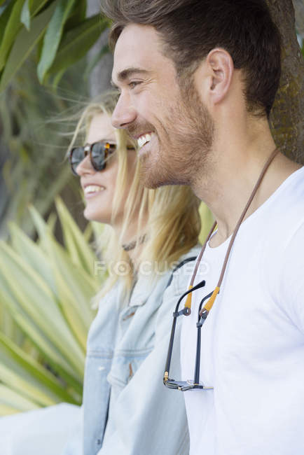 Nahaufnahme eines glücklichen jungen Paares, das in Pflanzen lächelt — Stockfoto