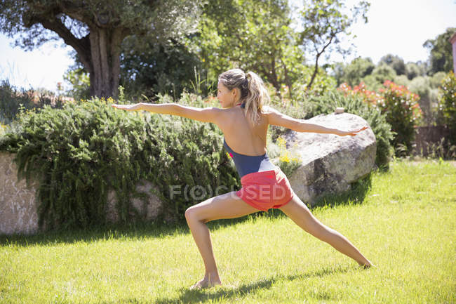 Donna sportiva che esercita sul prato in giardino — Foto stock
