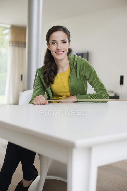 Портрет брюнетки счастливой женщины, сидящей за столом — стоковое фото