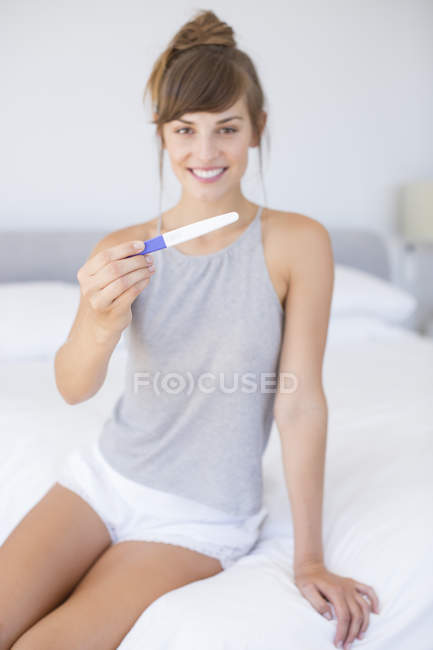 Femme heureuse montrant test de grossesse — Photo de stock