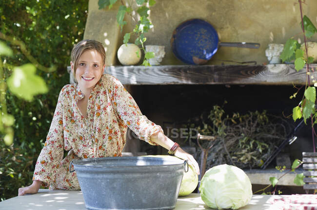 Portrait of a little girl with cabbage on table outdoors — Stock Photo