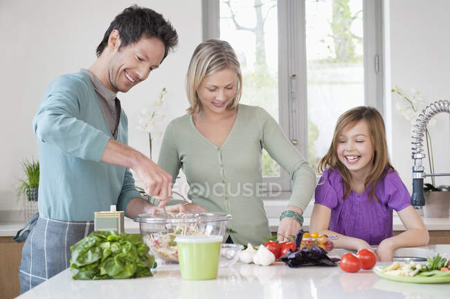 Familia preparando comida en la cocina - foto de stock