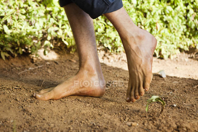 Low section of barefooted man standing on ground — Stock Photo