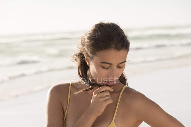 Gros plan de la jeune femme sensuelle regardant vers le bas sur la plage — Photo de stock