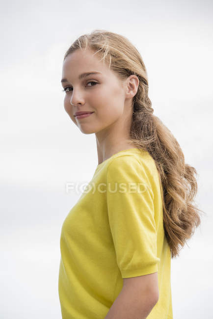 Portrait of smiling teenage girl in yellow sweater — Stock Photo