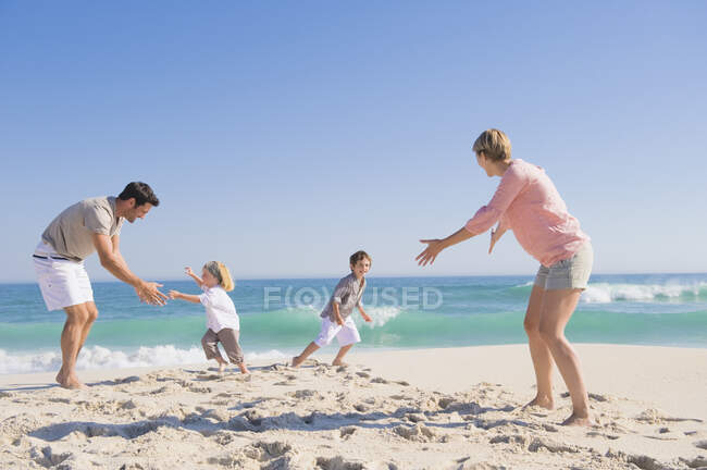 Сім'я насолоджується відпочинком на пляжі — стокове фото
