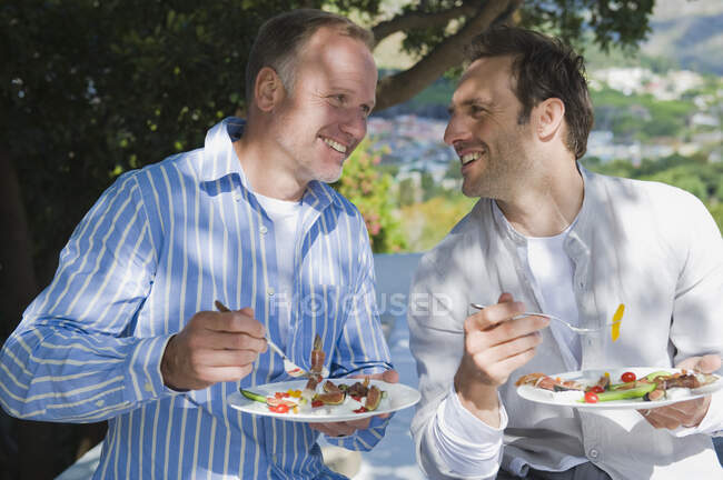 Dois amigos comendo salada de frutas — Fotografia de Stock