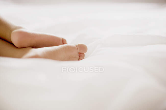 Human feet on bed — Stock Photo