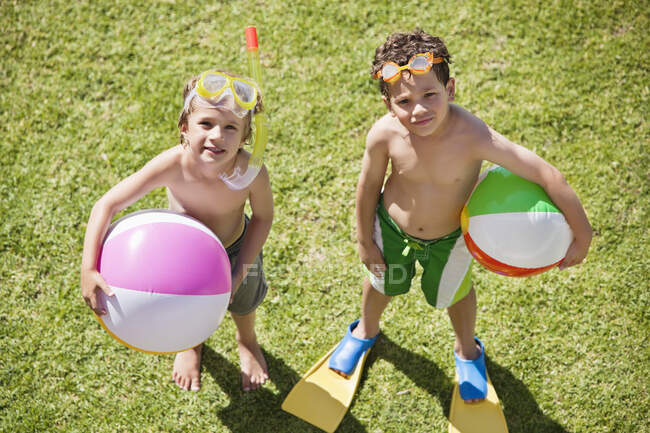 Retrato de niños sosteniendo pelotas de playa - foto de stock