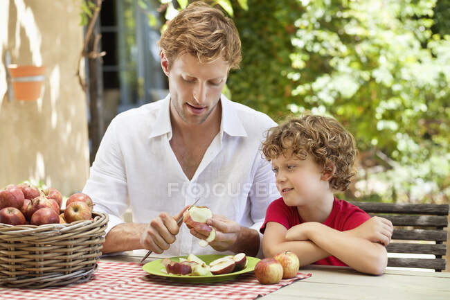Padre peeling mela con figlio — Foto stock