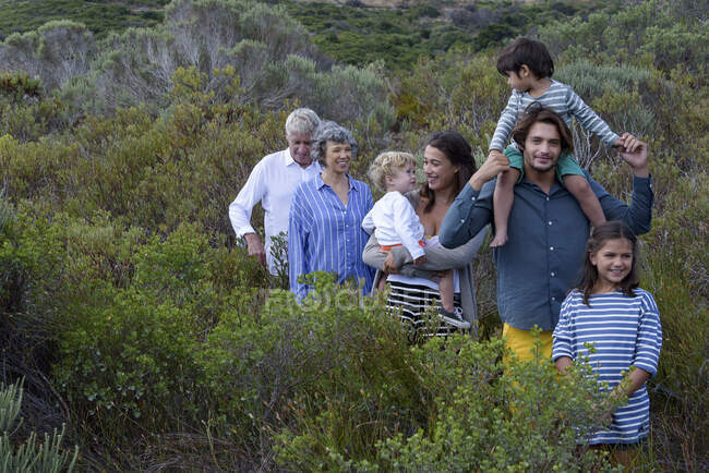 Feliz familia multi-generación caminando por el paisaje - foto de stock