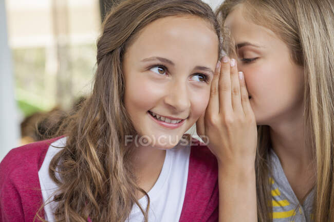Gros plan de deux filles chuchotant dans une école — Photo de stock