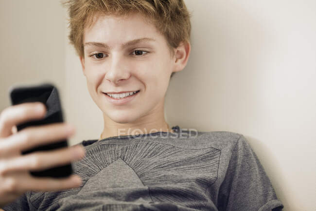 Teenage boy using phone — Stock Photo