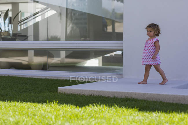 Linda niña caminando en repisa en verano al aire libre - foto de stock