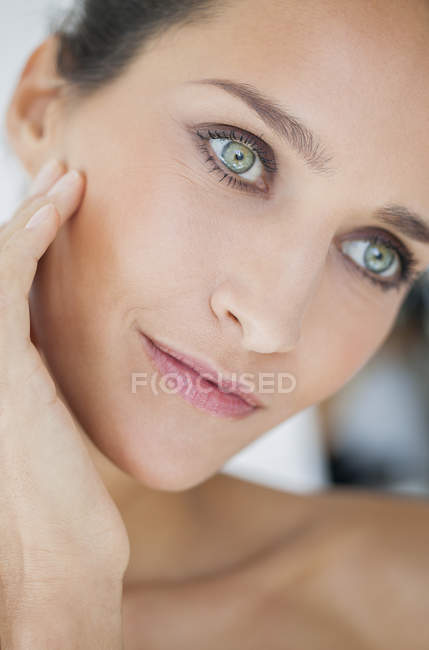 Портрет улыбающейся женщины с элегантным макияжем, смотрящей в сторону — стоковое фото