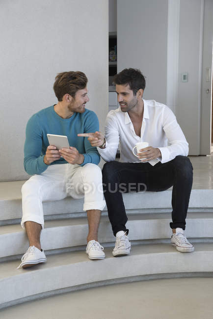 Щасливі чоловіки друзі використовують цифровий планшет на сходах — стокове фото