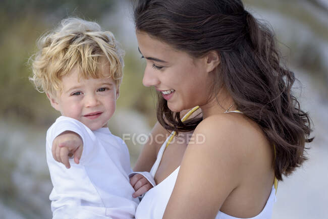 Mãe feliz com seu filhinho desfrutando na praia — Fotografia de Stock