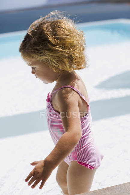 Close-up da menina em roupa de banho rosa andando perto da piscina — Fotografia de Stock