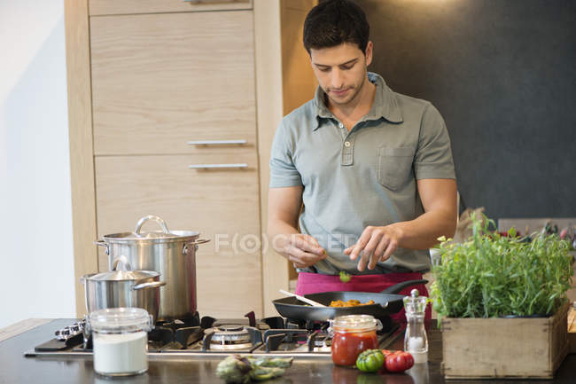 Hombre preparando comida en la cocina moderna - foto de stock
